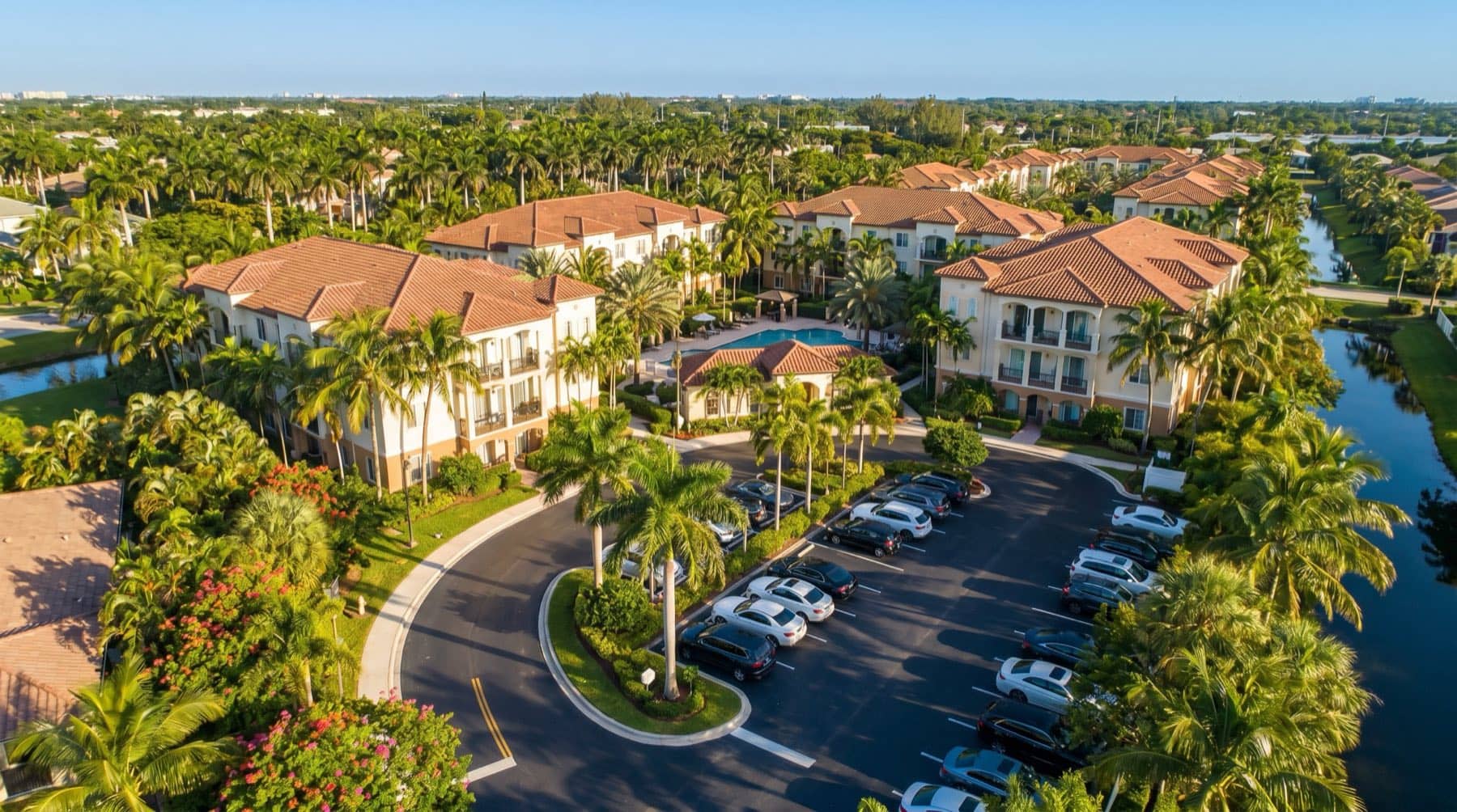 Aerial of a small Florida apartment complex with parking and palms, South Florida.