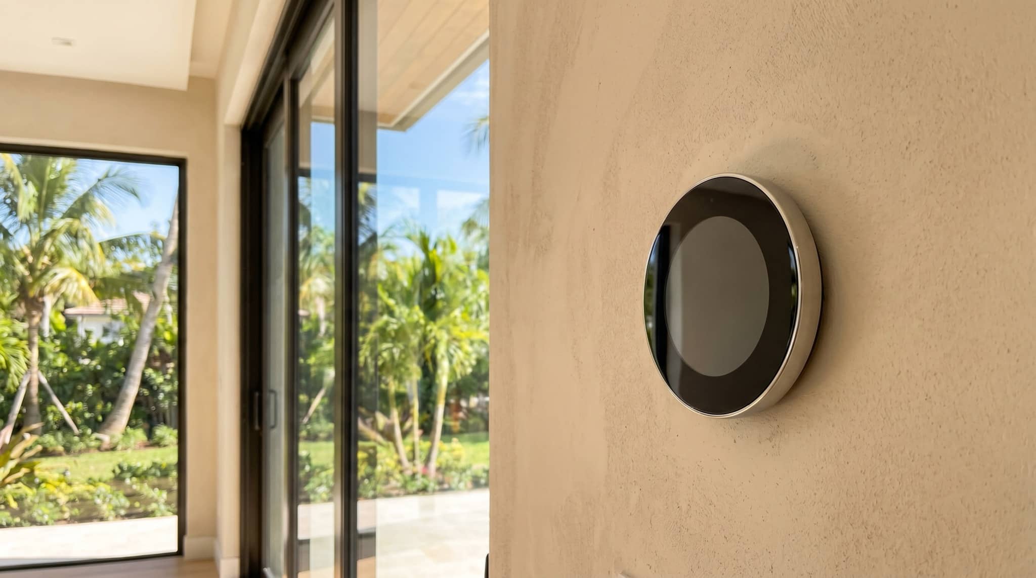 Modern smart thermostat on a wall in a bright interior, South Florida.